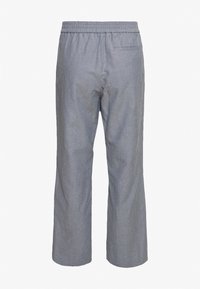 Grå avslappnade byxor med elastisk midja, subtil struktur och en bakficka. Vid bensnitt. Lätt viktsmaterial.