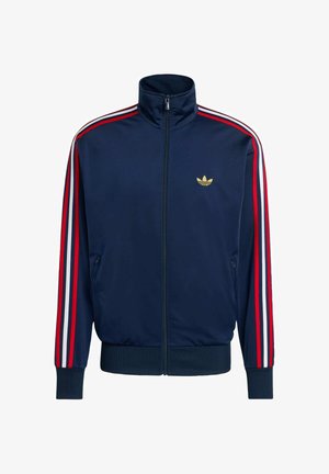 Marineblå polyester trackjakke med høj krave, guld logo, røde og hvide striber langs ærmerne og to sidelommer.