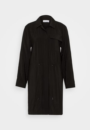 Svart, lett trenchcoat med nedknappbar krage, lange ermer, lommer foran og snøring i midjen for justering.