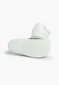 Sneaker bianco in tela con suola in gomma testurizzata, punta tonda e cinturino in velcro sul lato. Logo discreto sul tallone.