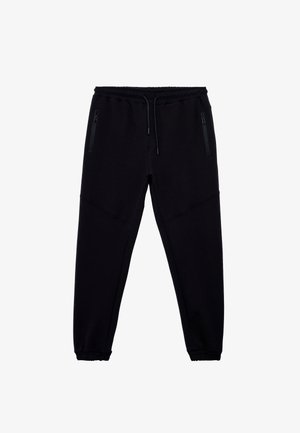 Schwarze Sweatpants aus weichem Material, mit einem elastischen Bund und Kordelzug, zwei seitlichen Reißverschlusstaschen und schmal zulaufenden Bündchen.