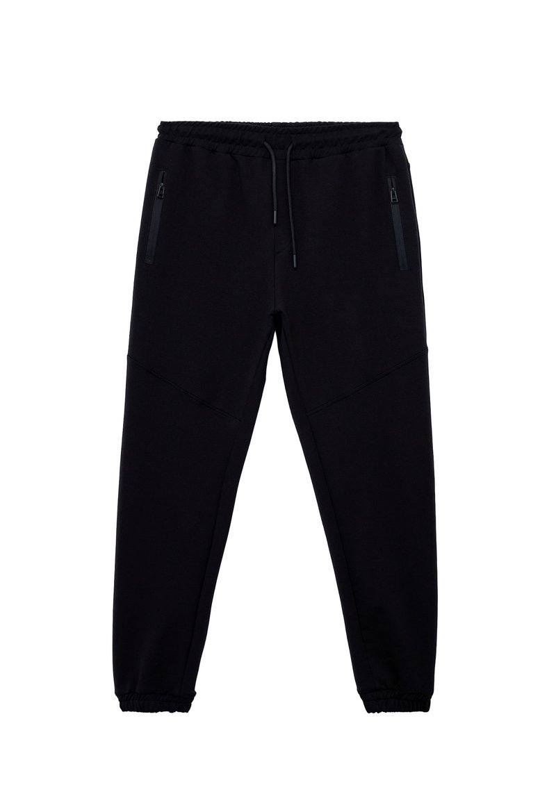 Sorte joggingbukser lavet af blødt stof, med elastisk talje med snor, to sidelommer med lynlås og indsnævrede manchetter.