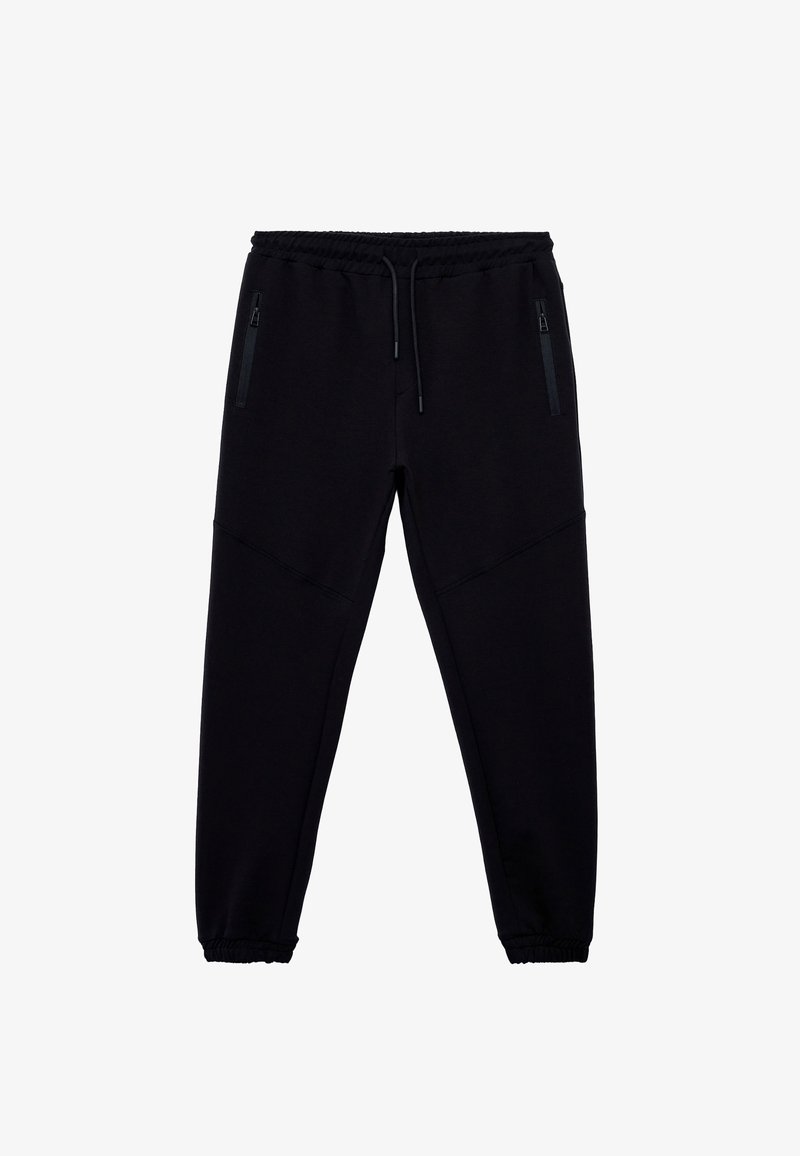 Sorte joggingbukser lavet af blødt stof, med elastisk talje med snor, to sidelommer med lynlås og indsnævrede manchetter.