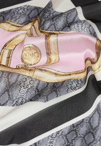Silk tørklæde med et pink og guld slange-motiv samt et mønster med sort og hvid strib, der viser en glat tekstur og levende farver.