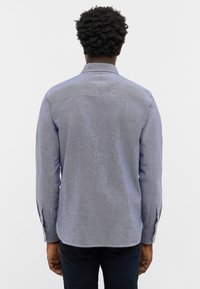 Blaues Langarmhemd mit feiner Textur, geknöpften Manschetten und klassischem Kragen; hat ein Rückenschulterdesign.