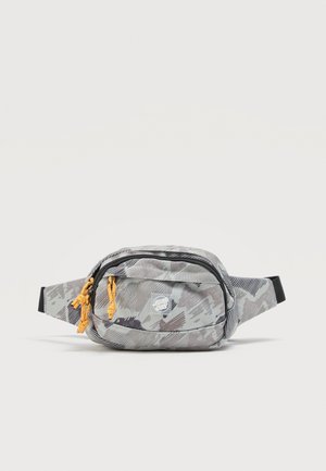 Sivý maskáčový bedrový vak s čiernymi zipsami, žltými ťahadlami zipsov a malým kruhovým logom "Santa Cruz" na prednom vrecku.