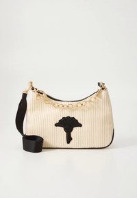 Bolso tejido color crema con un adorno floral negro, asa de cadena dorada y una correa negra para el hombro desmontable. Textura suave.