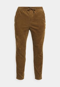 Pantalons en velours côtelé marron avec une coupe fuselée, taille élastique et cordon de serrage. Présente une texture côtelée verticale et des poches latérales.