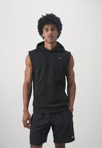 Fekete ujjatlan kapucnis felső, elülső zsebbel, sima anyagból készült, a mellrészen egy diszkrét logóval; fekete rövidnadrággal párosítva.