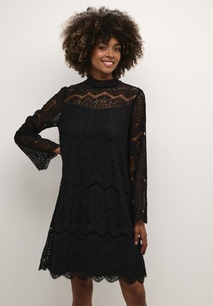 Black lace dress with a high neck, long sleeves, and a scalloped hem. Features intricate patterns and a lightweight, textured fabric.