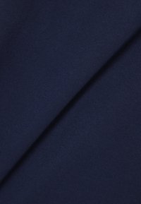 Tela de azul marino oscuro doblada en diagonal, mostrando una textura suave y un patrón fino de tejido.