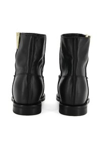 Schwarze Leder-Stiefeletten mit glatter Textur, hervorgehobener Hinternaht und einer goldenen Zipper-Akzent an der Seite. Flache Gummisohle.