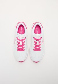Baskets blanches de sport avec des accents roses. Elles disposent de lacets roses et d'une doublure intérieure rose, avec un logo discret sur les côtés extérieurs. Texture lisse.