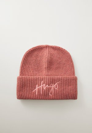 Knit beanie in soft, rosy pink with a ribbed texture and a rolled cuff, featuring embroidered “Hugo” in lighter pink thread.
