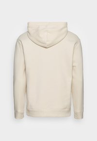 Gräddfärgad hoodie med mjuk textur, utrustad med en huva med dragsko samt ribbade muddar och fåll, visad bakifrån.