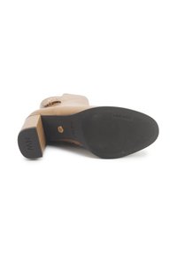 Bež kožne čizme do članaka s blok petom, detaljem kopče i crnom gumenom potplatom s NINE WEST oznakom.