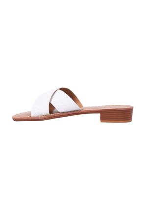 Sandali piatti in glitter bianco con cinturini incrociati, suola in legno piatta e tacco basso, caratterizzati da una fodera interna liscia.