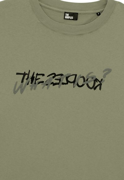 Ελαιόχρωμο βαμβακερό μπλουζάκι με ελαφρώς θολή μαύρη και γκρίζα γραφική σχεδίαση κειμένου, με στρογγυλή λαιμόκοψη και κοντά μανίκια.