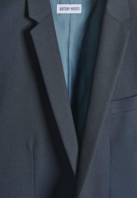 Blazer navy di Antony Morato con tessuto texturizzato, rever affilati e una fodera interna di un azzurro chiaro in contrasto. Include una tasca laterale.