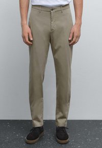Beige chinos i mjukt tyg med dragkedja och enkel knappstängning. Matchat med mörkbruna mockaskor.
