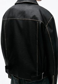 Black faux leather jacket featuring a classic collar, visible stitching, side zippers, and a slightly cropped cut at the waist.