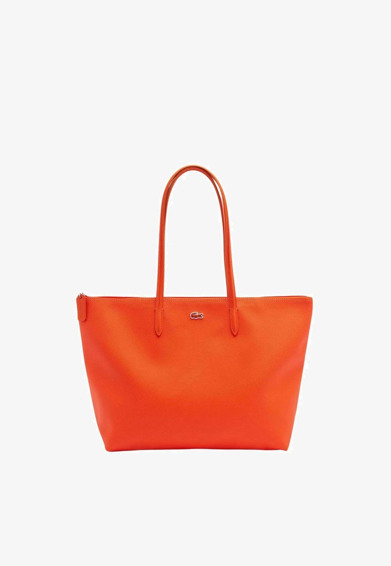 Bolso tote naranja hecho de material suave, con dos asas resistentes, cierre superior con cremallera y un pequeño logo en la parte frontal.
