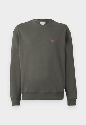 Donkergroene crewneck sweatshirt van katoen. Heeft een klein roze 'ck' logo op de linkerkant van de borst en ribgebreide boorden en onderkant.