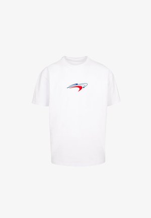 Valge puuvillane T-särk ümmarguse kaelusega. Rinnapiha piirkonnas on väike sinise ja punasega dünaamilist kuju meenutav graafika.