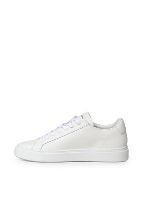 Sneaker in pelle bianca a taglio basso con lacci bianchi e suola spessa bianca, vista laterale su sfondo bianco.