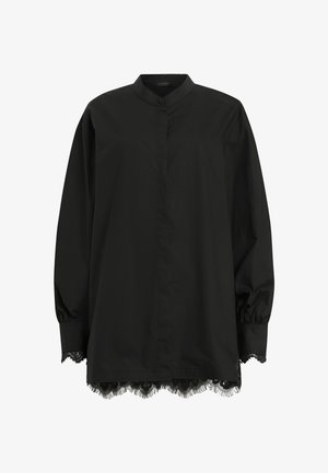 Blouse noire à manches longues en tissu lisse. Présente un col mandarin, une fermeture par boutons et une finition en dentelle au bas de l'ourlet.