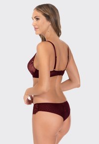 Bordowa, koronkowa bielizna w zestawie z majtkami; cechuje się miękkim materiałem, regulowanymi ramiączkami oraz koronkowymi detalami na bokach majtek.
