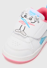 White sneaker with blue accents and pink sole. Features a cartoon graphic on the strap. Made of smooth material, with perforated detailing.