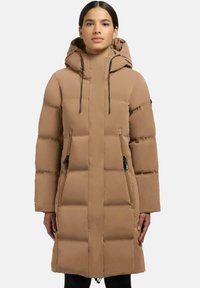 Uldne lang frakke i tan med hætte, forsynet med en frontlynlås og sidelommer. Glat tekstur med quiltede mønstre for isolering.