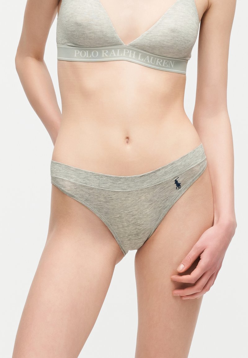 Γυναίκα με ανοιχτό γκρι bralette Polo Ralph Lauren και ταιριαστό εσώρουχο σε μπικίνι με κέντημα λογότυπου στο ισχίο, σε λευκό φόντο.