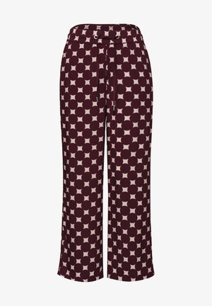 Wijde broek met groot polkadotpatroon in bordeauxrood en beige, elastische tailleband en koordsluiting aan de voorkant.