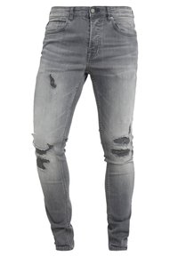 Jeans in denim grigio slim-fit con dettagli strappati. Presentano strappi e finiture sfrangiate sulla parte anteriore, design a cinque tasche e chiusura con bottone standard.