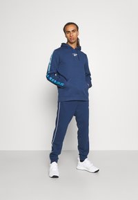 Reebok PIPING JOGGER - Calças de fato de treino - batik blue