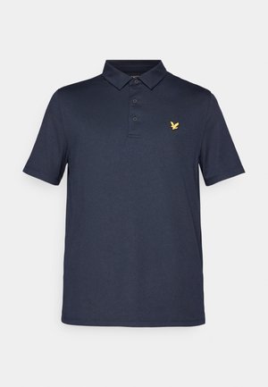 Polo azul marino con un frente de dos botones, mangas cortas y un pequeño emblema dorado de un pájaro en el lado izquierdo del pecho. Hecho de una tela suave.