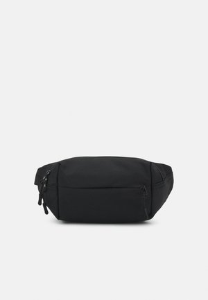 Sort talje taske med flere lynlåslommer og justerbar rem, vist på en ensfarvet lys baggrund.