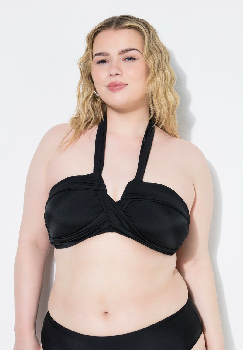 Top bikini nero con un design incrociato davanti, realizzato in materiale morbido ed elastico, dotato di spalline a halter e finitura senza cuciture.