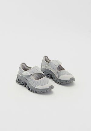 Gray lightweight shoes with a mesh upper and cushioned midsole. Features a hook-and-loop strap and rounded toe with cut-out sole design.
