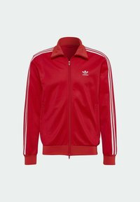 Red zip-up track jacket made of smooth fabric, featuring white stripes on sleeves, a ribbed collar, and elastic cuffs. Brand logo on chest.