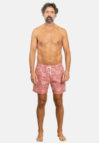 Bañador rojo con un patrón floral, hecho de una tela ligera, que cuenta con una cintura elástica y un cordón blanco para ajustarse.