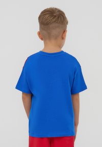 T-shirt a maniche corte in cotone blu brillante con scollatura rotonda. Il retro è semplice, con una vestibilità comoda. Accenti rossi sulle spalle.