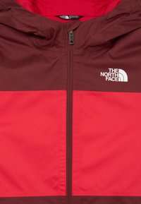 Červená a gaštanová zipová bunda s kapucňou, na pravej hrudi s logom The North Face.