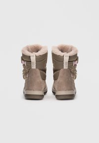 Bottines avec une tige textile olive lisse, doublure en fausse fourrure et accents en suède marron clair. Deux détails en forme de nœud rose sur les côtés.
