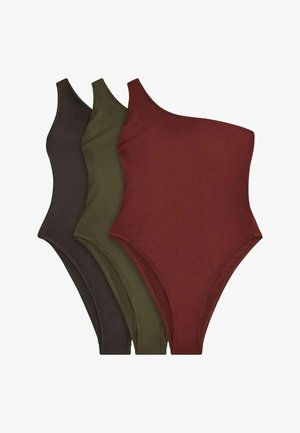 Három bordázott, egyrészes testhez simuló felső egy vállon, barna, olívazöld és rozsdavörös színekben, egymás mellett fehér háttéren elhelyezve.