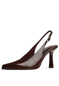 Brown leather slingback pump with a pointed toe, slender heel, and a smooth texture. Features an adjustable strap and minimalist design.