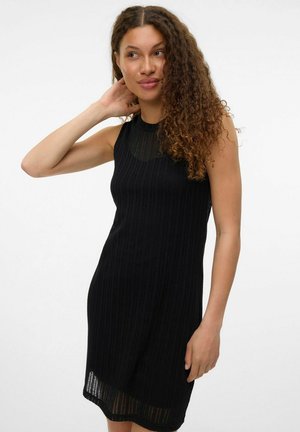Black ribbed dress with a sleeveless design, featuring a round neckline and a slight transparency at the hem. Soft knit texture.