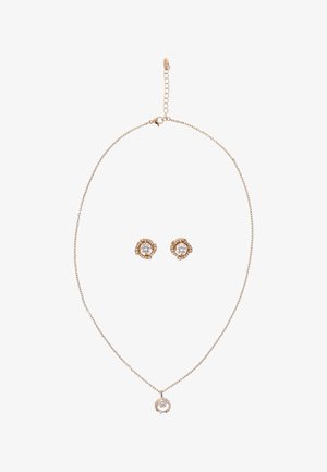 Arany lánc nyaklánc kör alakú gyémánt medállal és hozzáillő arany fülbevaló központi gyémántokkal és apró környező kövekkel.